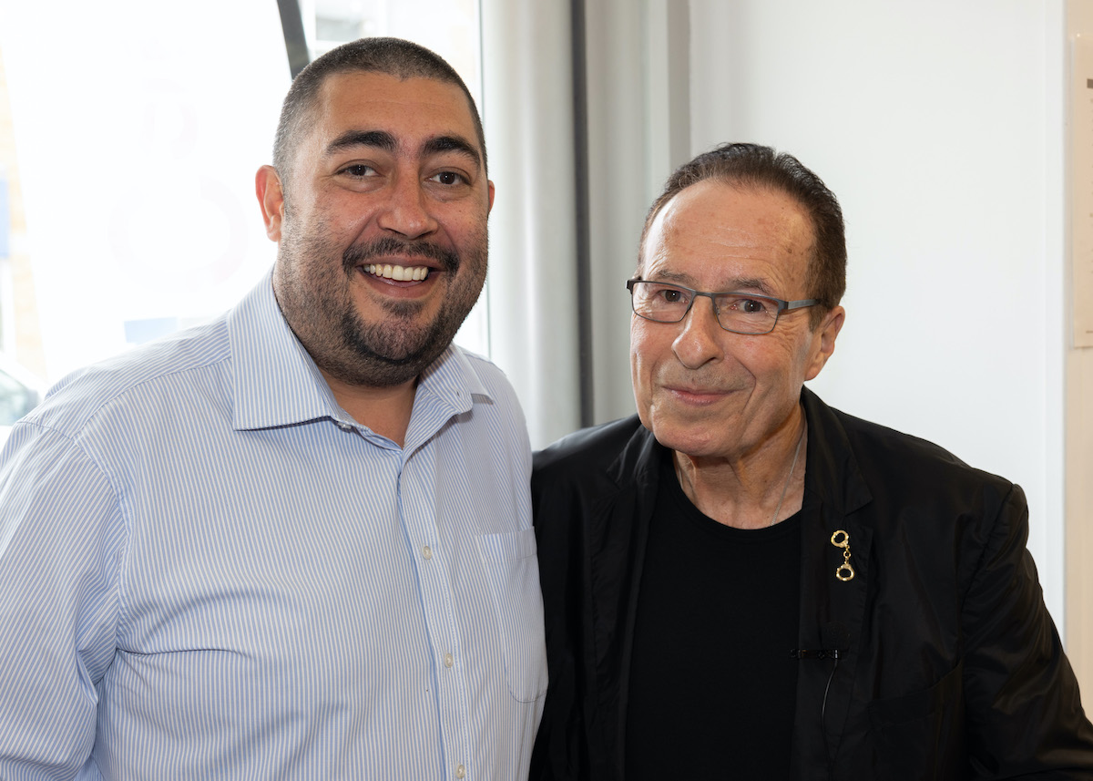 Two men standing next to each other smiling.