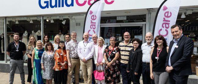 The Guild Care team at the new store on George Street, Hove. Article for Title Sussex www.titlesussex.co.uk A group of people, men and women, standing outside a shop.
