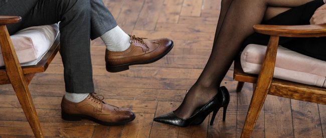 Who gets what after a divorce Title Sussex Magazine www.titlesussex.co.uk Image shows mans legs and womans legs from knee down. They're sitting opposite each other, representing separation
