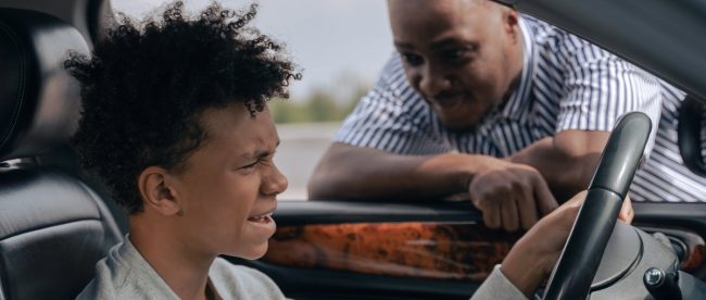 Borrowing parents car what to do Title Sussex Magazine Image shows a young man at the wheel of the car with his worried looking dad looking through the window