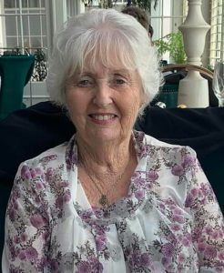 Elderly woman with white hair sat in armchair, smiling. Southwick Players Muswell Hill upcoming performance