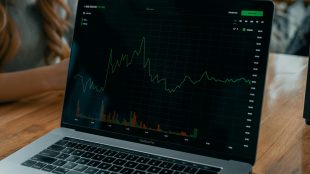 Image shows computer screen with trading graphs