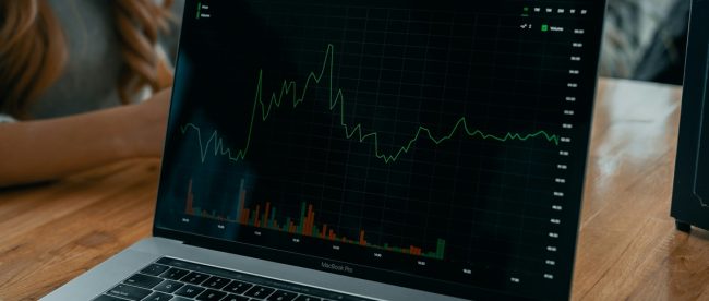 Image shows computer screen with trading graphs