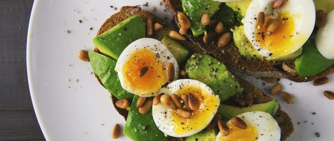 avocado and egg on bread with leafy greens
