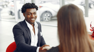 Two people sitting down and shaking hands.