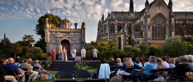 Image shows outdoor theatre taking place with backdrop of Arundel Castle behind the performers